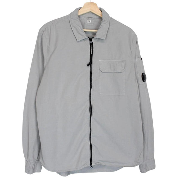 CP Company grey full zip overshirt jacket with lens detail and cotton material.