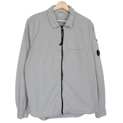CP Company grey full zip overshirt jacket with lens detail and cotton material.