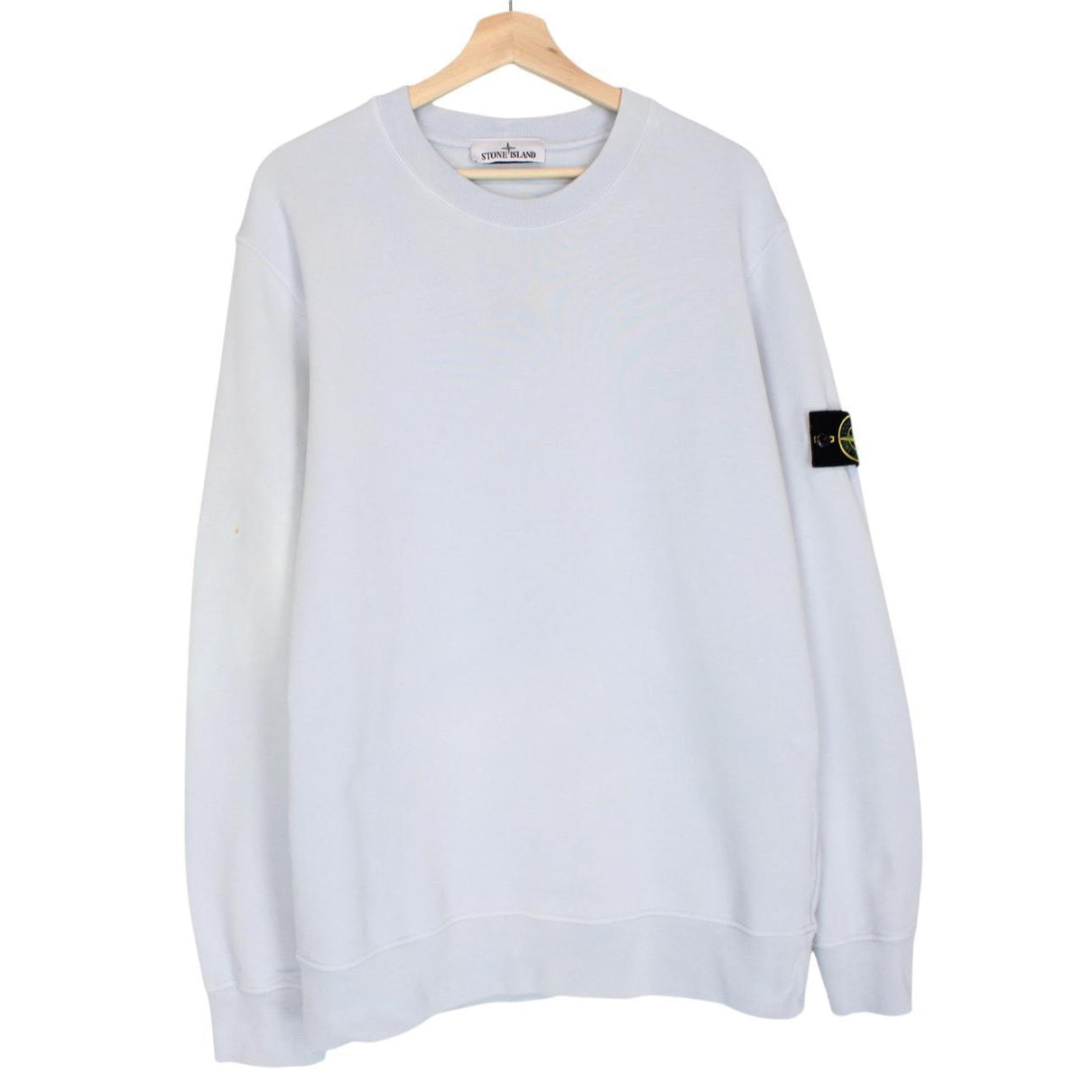 Stone Island blue cotton sweatshirt with logo patch and faded left sleeve.