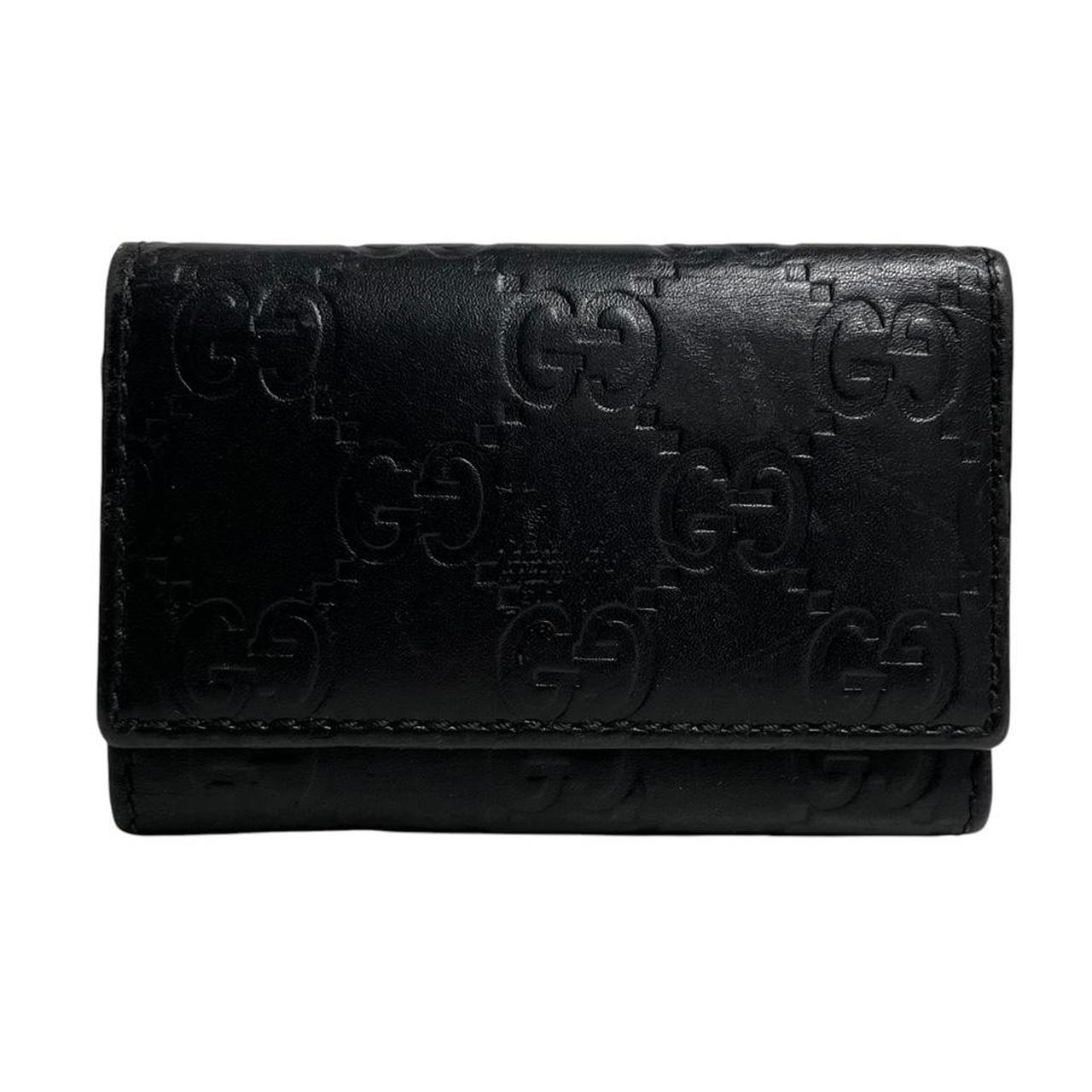 Gucci black leather key case featuring GG monogram pattern and scuffed details.