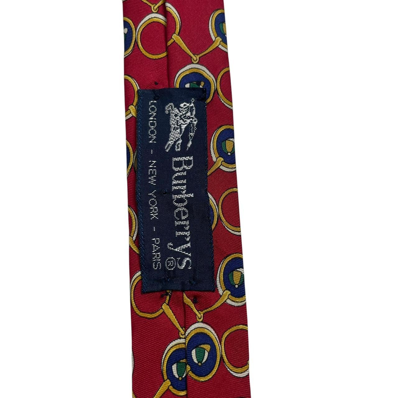 Burberry red silk tie featuring vintage horsebit print design.