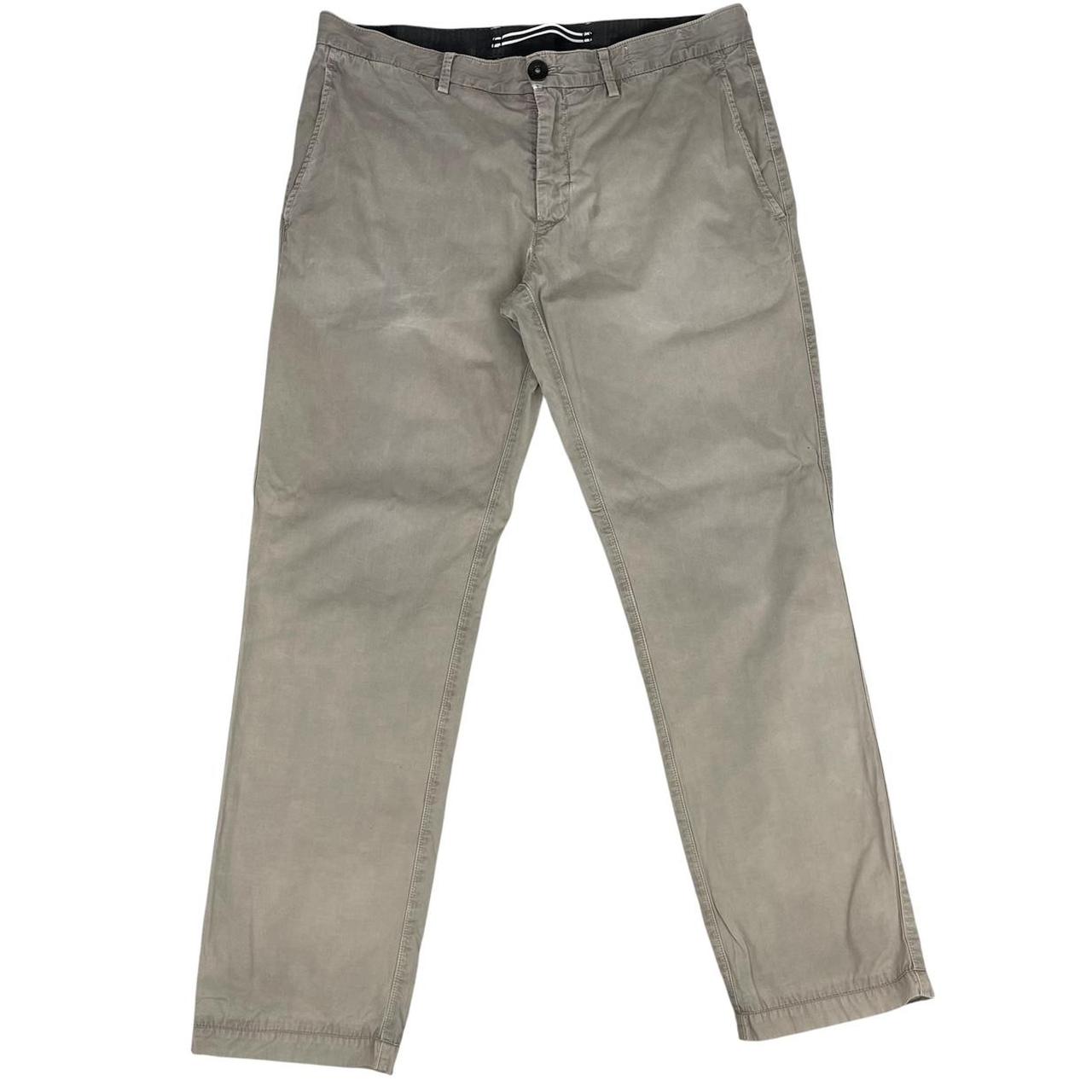 Stone Island beige slim fit cotton trousers with logo patch and visible wear marks.