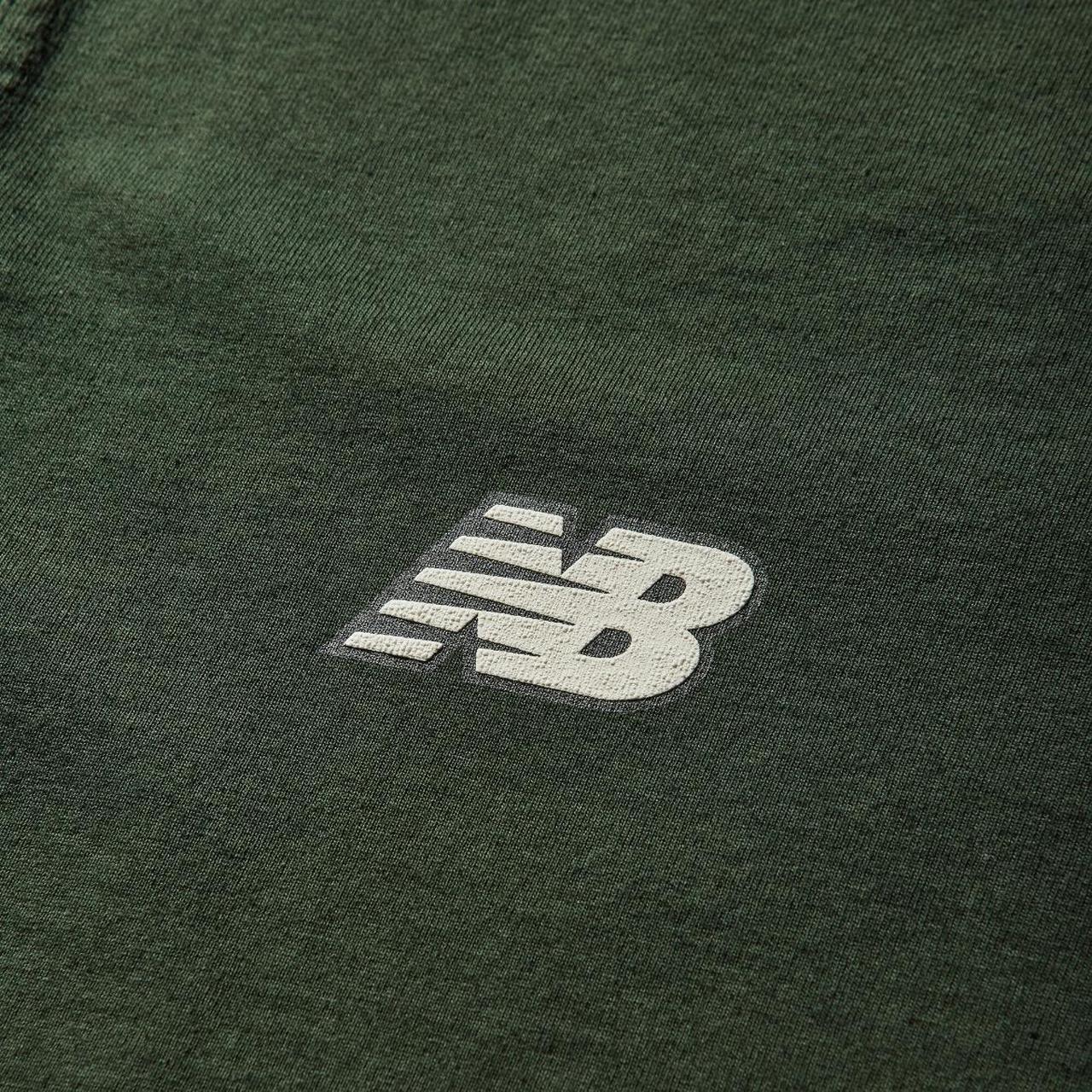 Stone Island green pocket t-shirt with embroidered crest and New Balance logo.