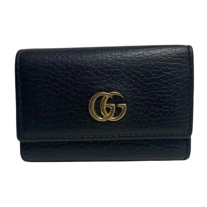 Gucci black leather key case with GG logo and quilted pattern.
