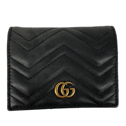 Gucci black calfskin wallet with matelassé pattern and GG logo detail.