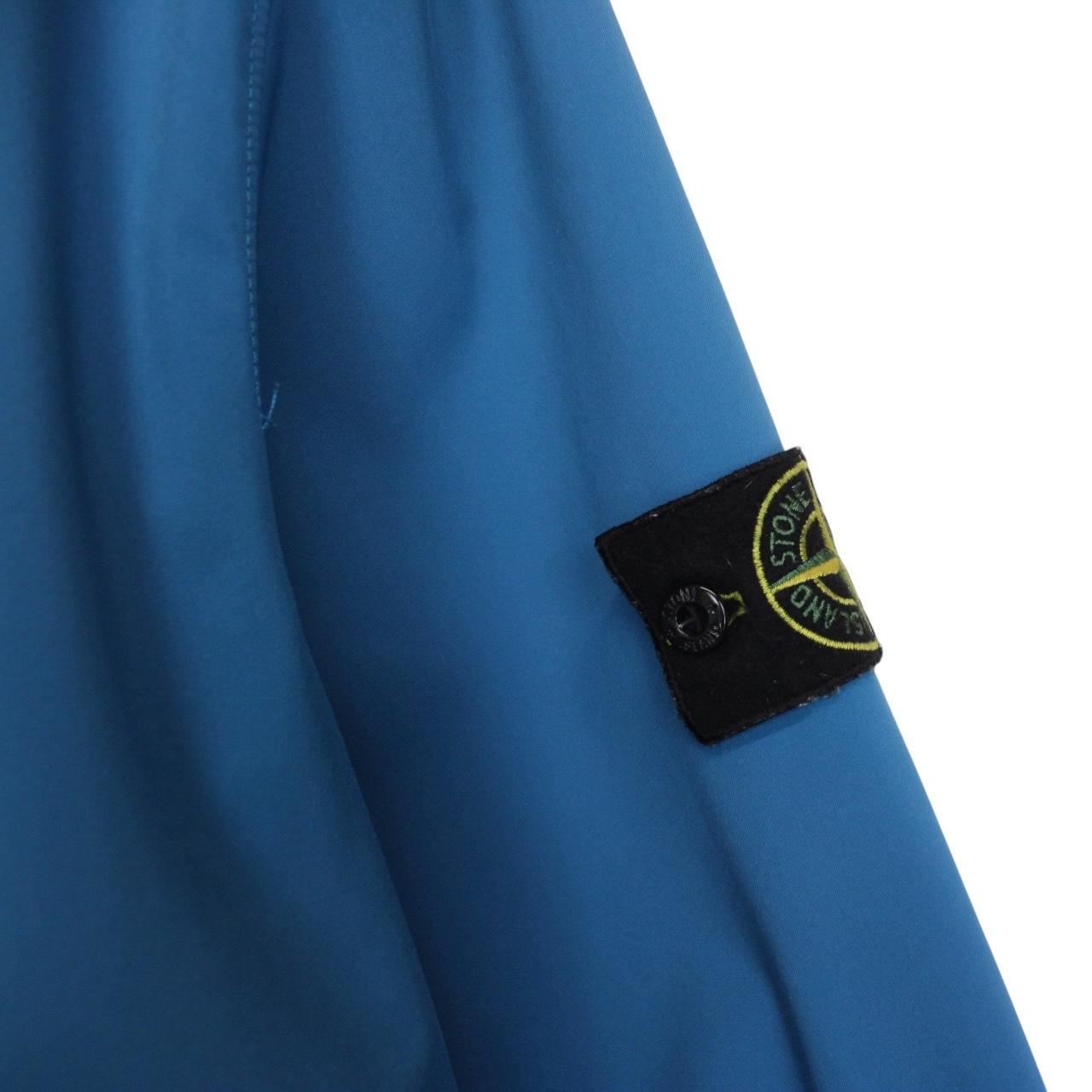 Stone Island blue full zip jacket with logo patch and soft shell material.