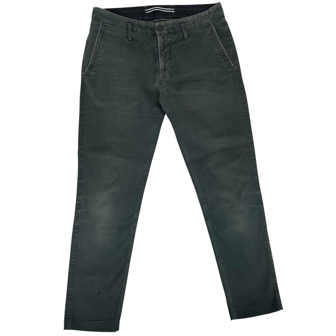 Stone Island green slim fit cotton trousers with logo patch and faded details.
