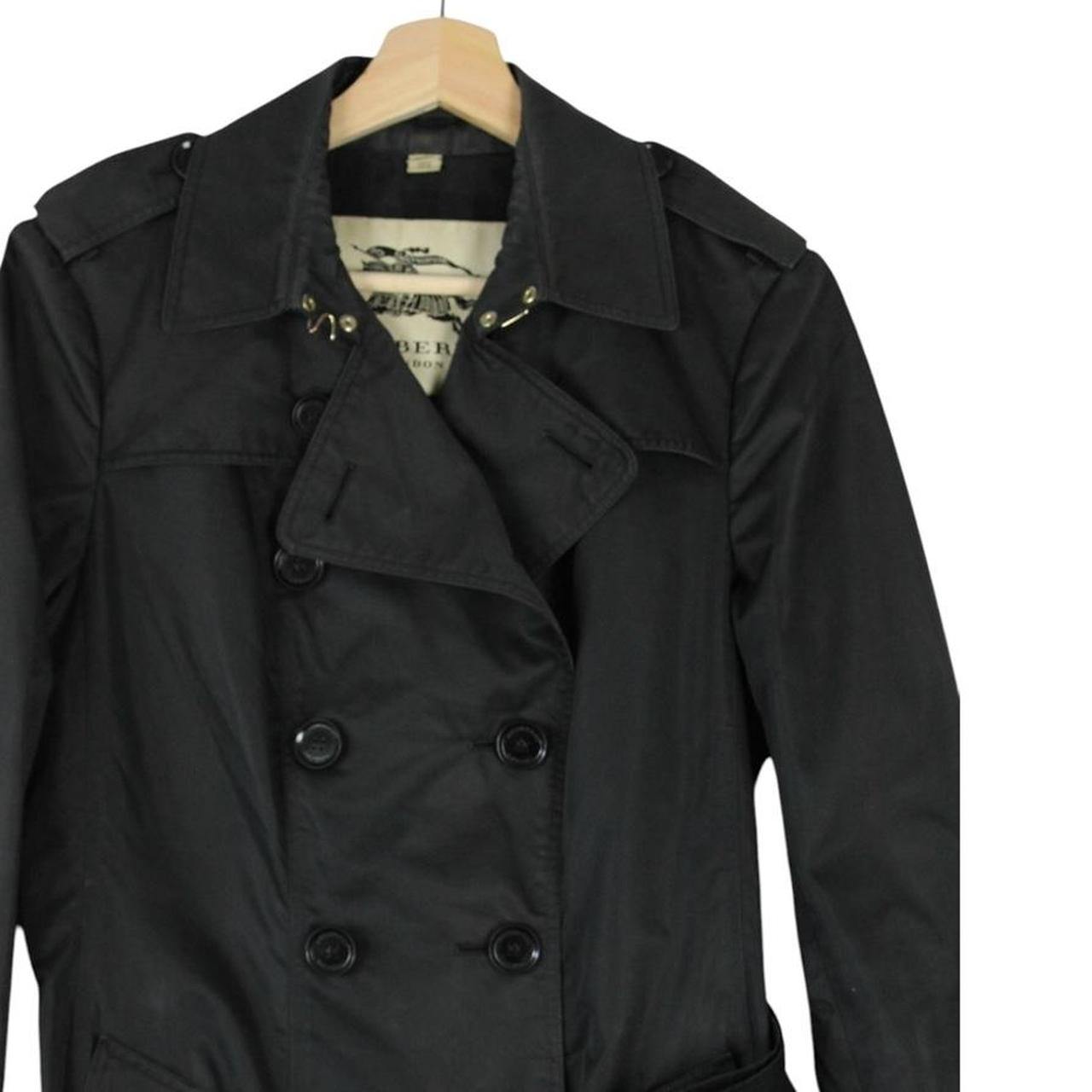 Burberry black double breasted belted trench coat with logo detailing and classic design.