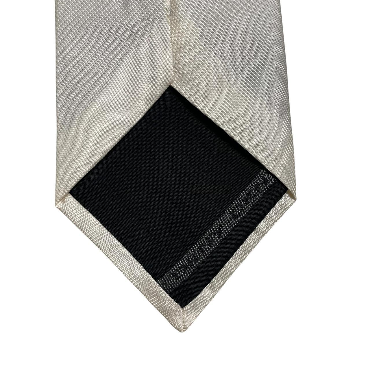 DKNY white silk tie with smooth texture and classic design.