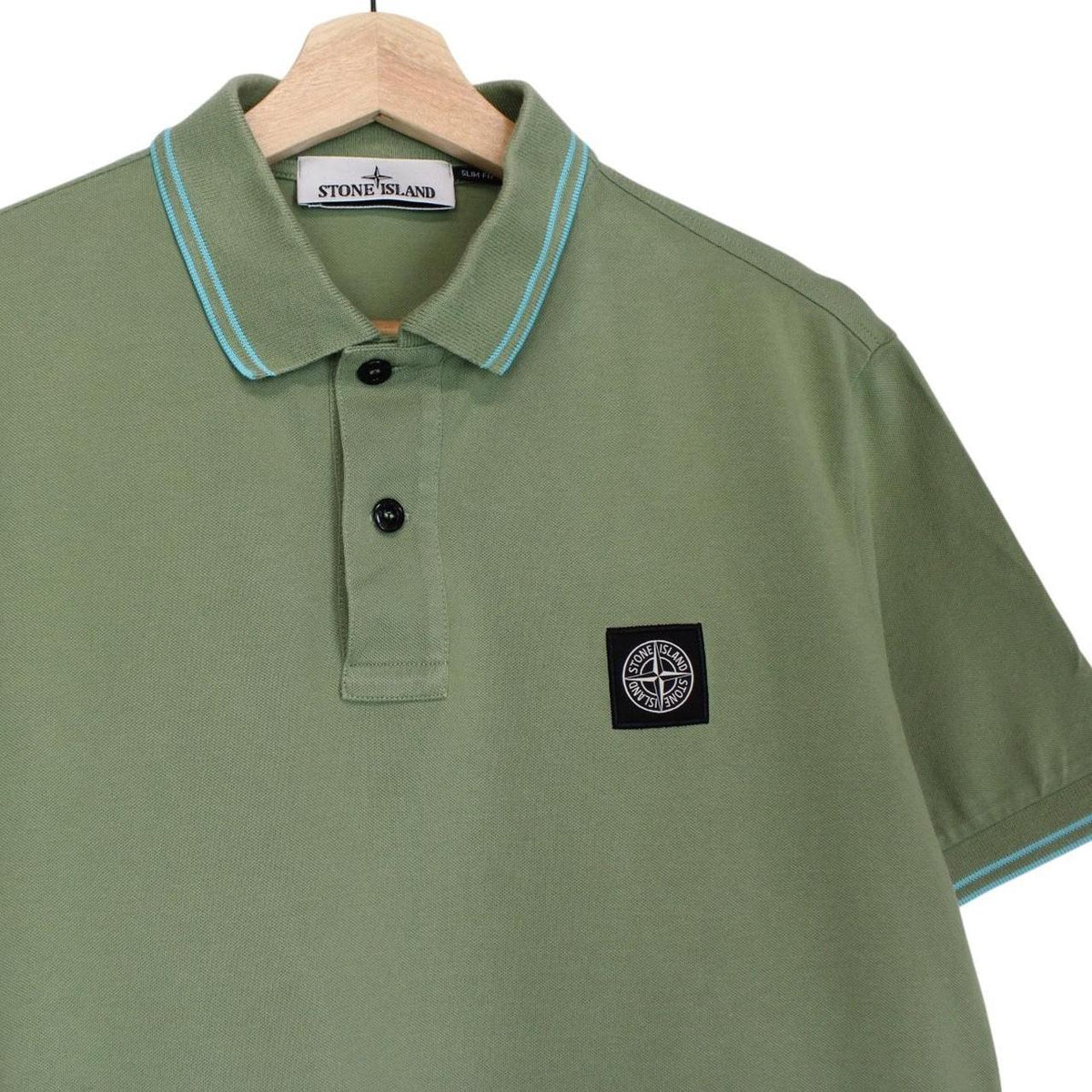 Stone Island green polo shirt with embroidered compass logo and cotton material.
