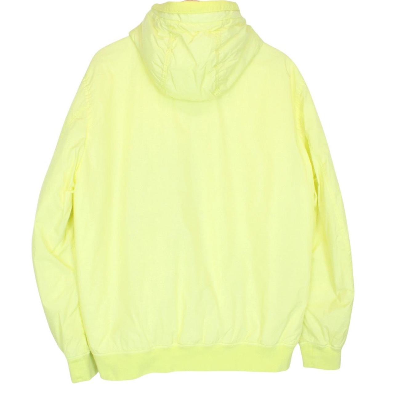 Stone Island yellow jacket with crinkle texture and logo badge on sleeve.