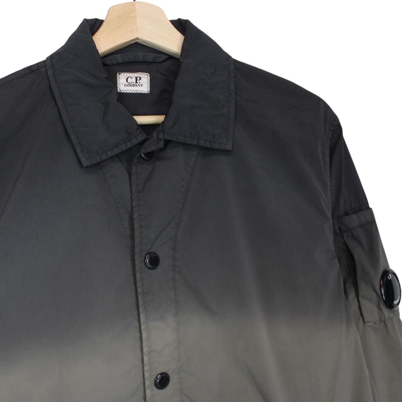 CP Company khaki green and grey jacket with shibori pattern and lens detail.