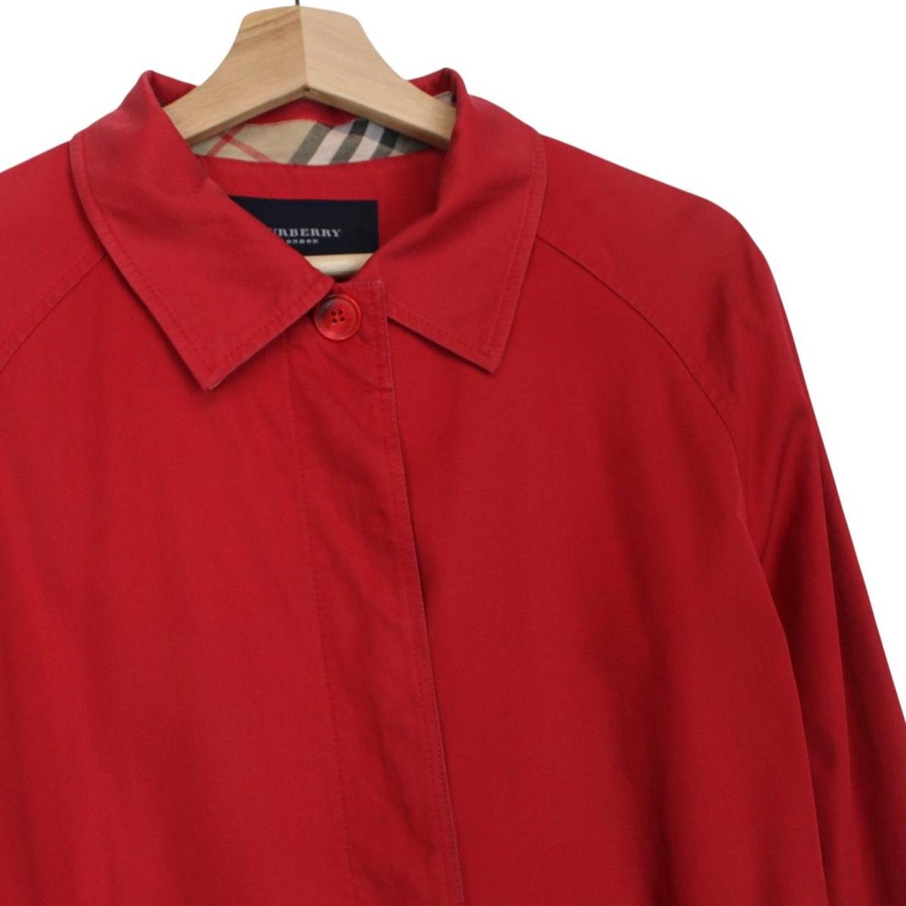 Burberry red trench coat with Nova Check pattern and belted waist detail.