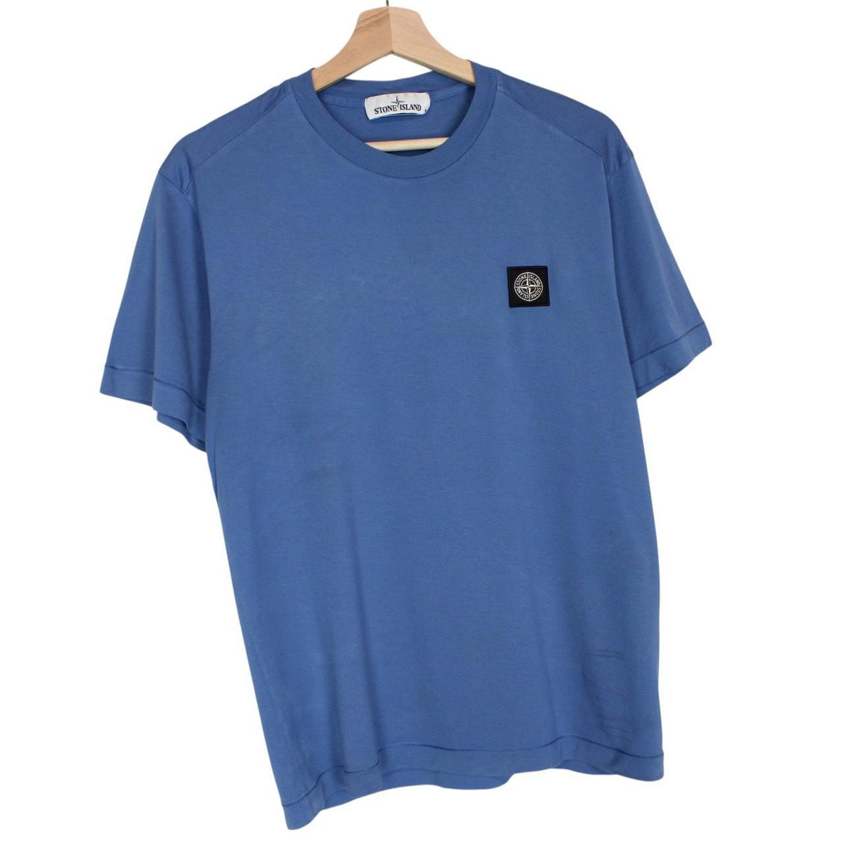 Stone Island blue short sleeve cotton t-shirt with compass logo and visible wear marks.