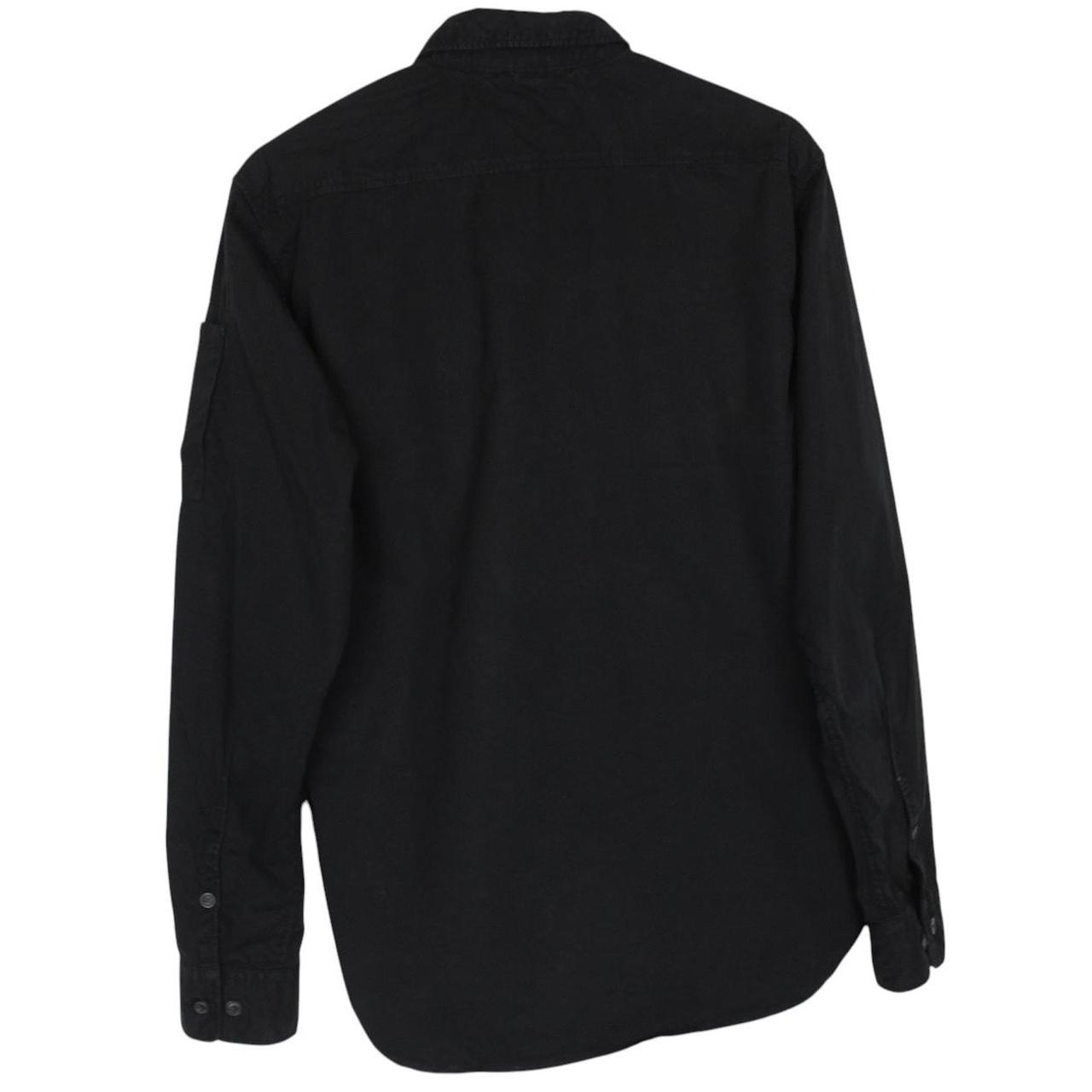CP Company black button-up jacket with lens detail and cotton material.