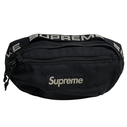Supreme black waist bag featuring logo print and durable material.