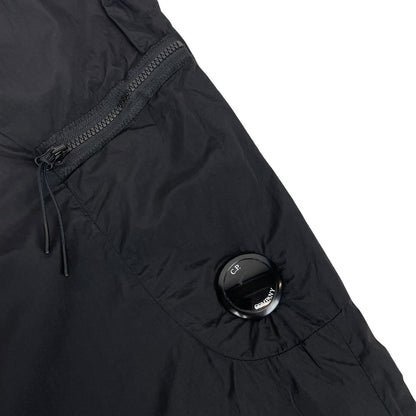 CP Company black cargo trousers with lens detail and nylon material.