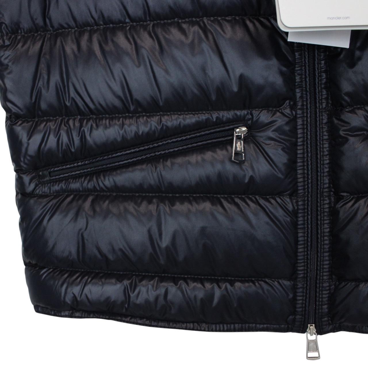Moncler navy blue down gilet with logo patch and quilted design.
