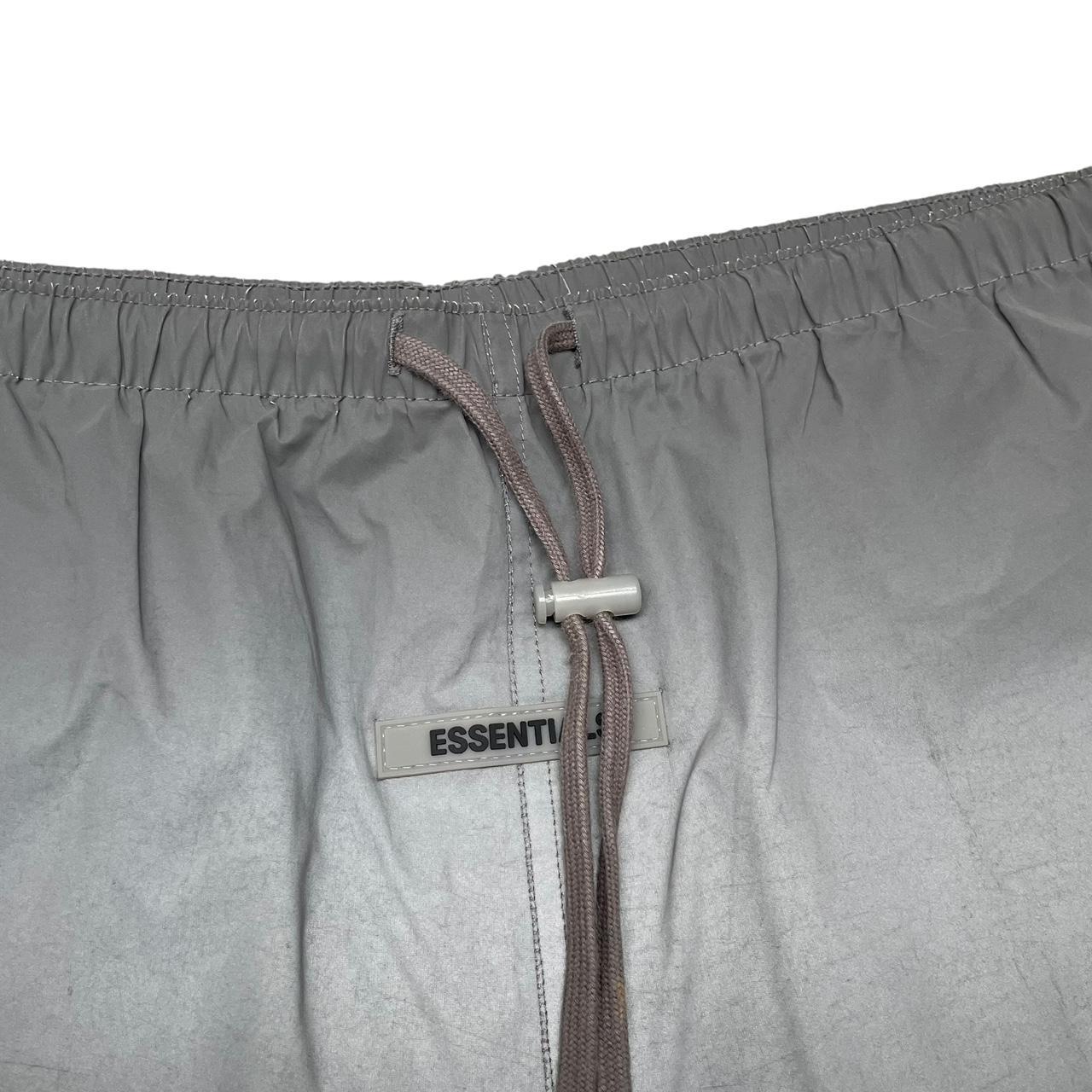 Essentials silver reflective nylon shorts with logo detail and sleek design.