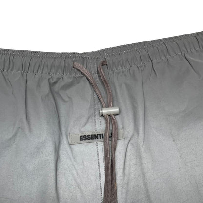 Essentials silver reflective nylon shorts with logo detail and sleek design.