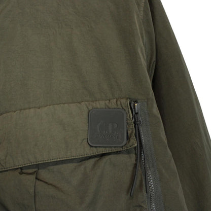 CP Company green hooded jacket with chrome detailing and logo patch on sleeve.