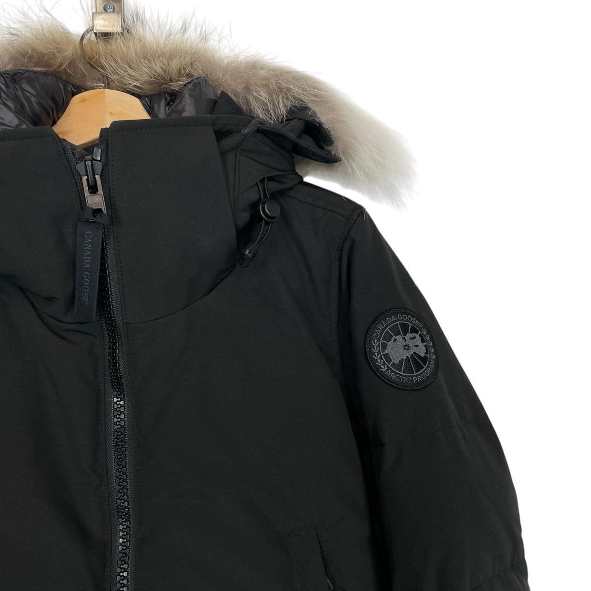 Canada Goose black parka with fur trim, logo patch, and down insulation.