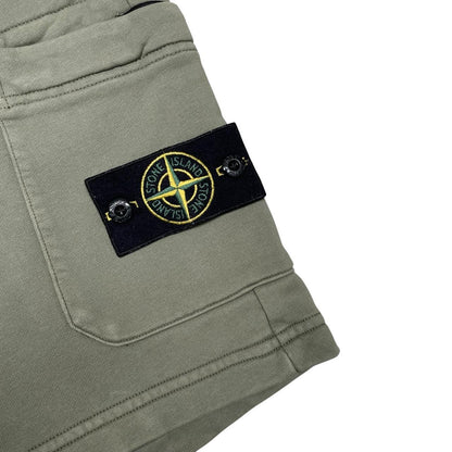 Stone Island green jogger shorts with logo patch and cotton material.