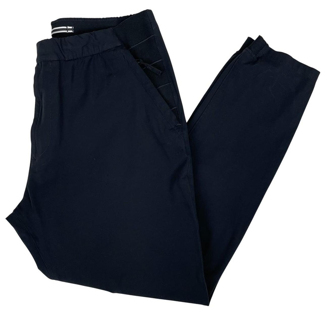 Stone Island navy blue joggers with logo patch and nylon material.