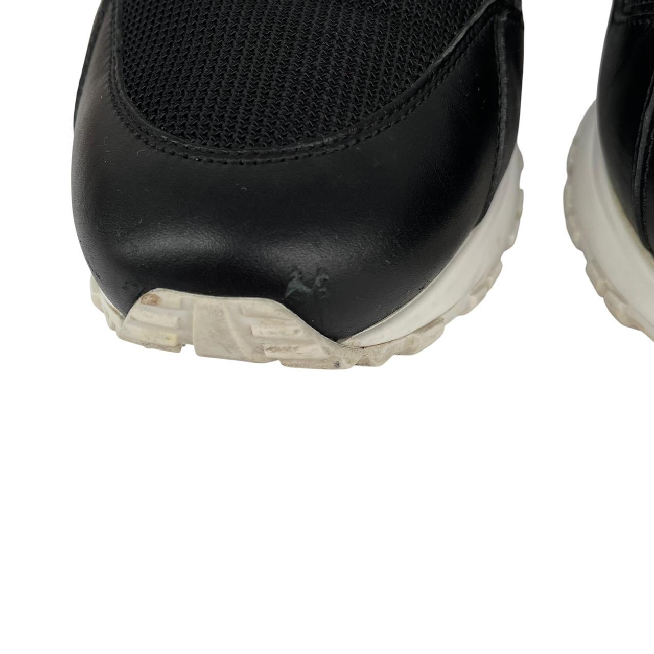 Louis Vuitton black trainers featuring monogram pattern and leather-mesh material.