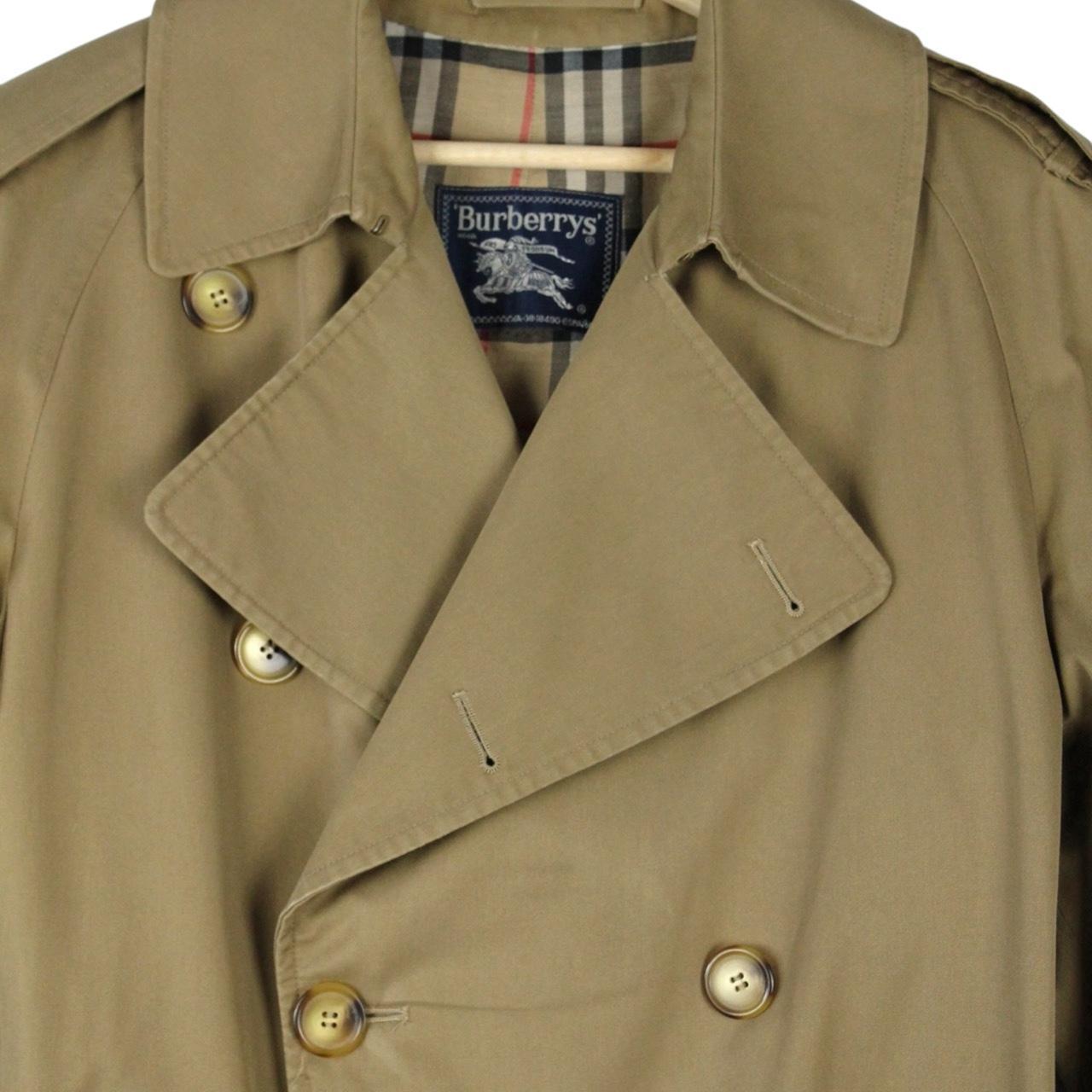Burberry brown double breasted belted trench coat with classic check lining and logo details.