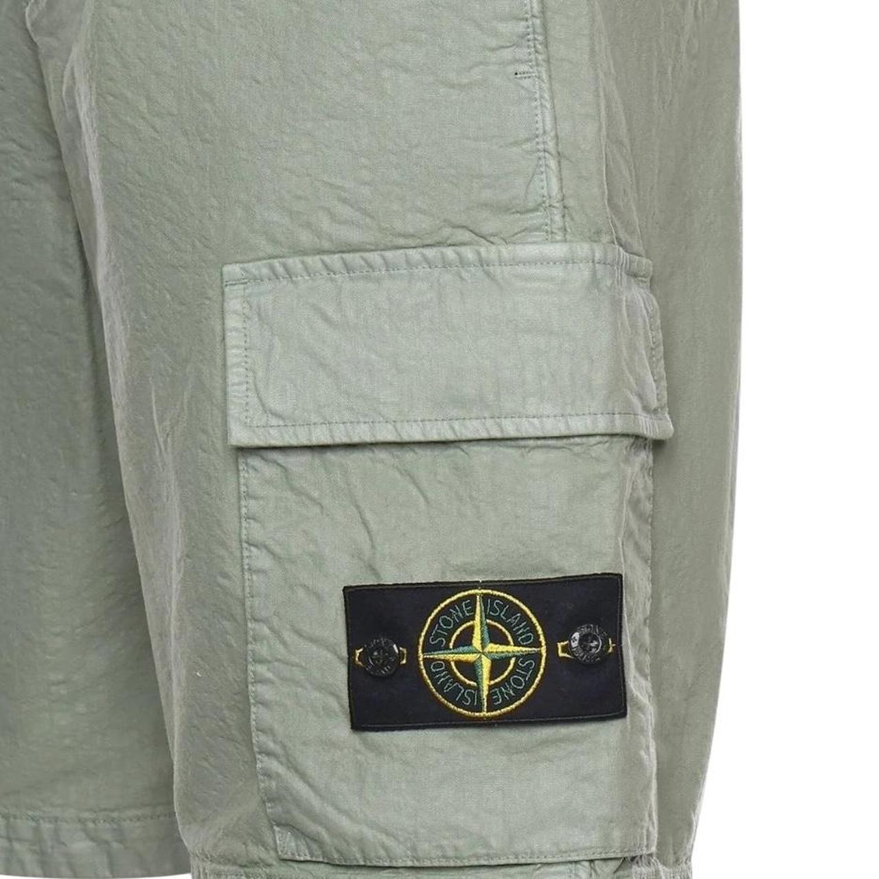 Stone Island green cargo shorts with multiple pockets and "OLD" effect garment-dye treatment.