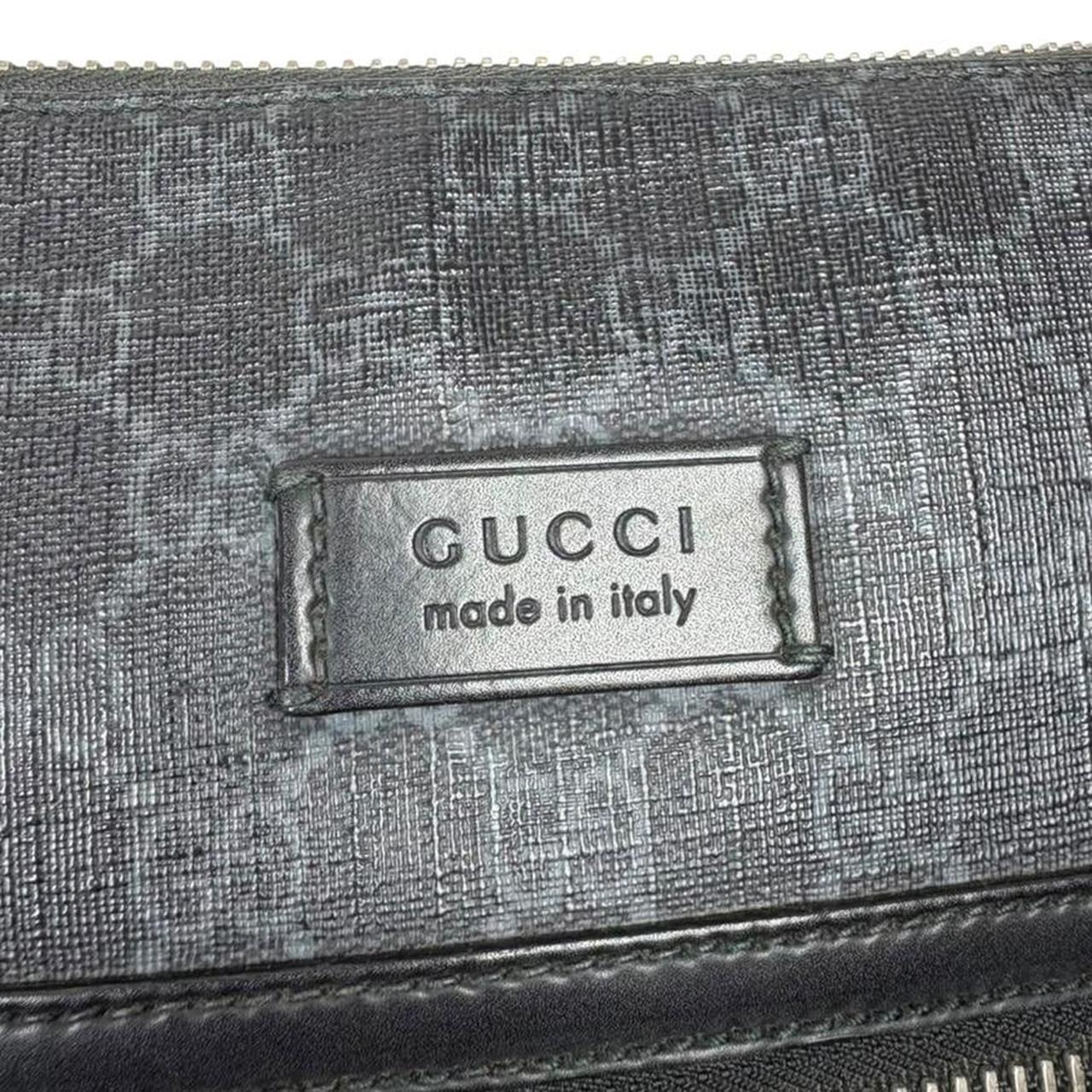 Gucci black duffel bag featuring GG Supreme monogram pattern and adjustable strap.