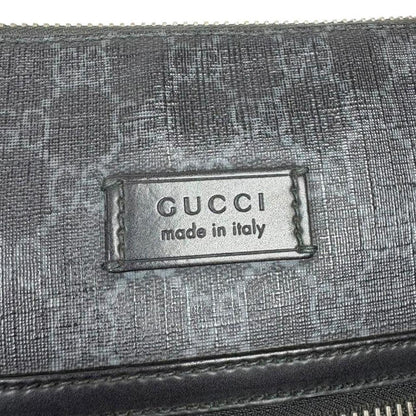 Gucci black duffel bag featuring GG Supreme monogram pattern and adjustable strap.