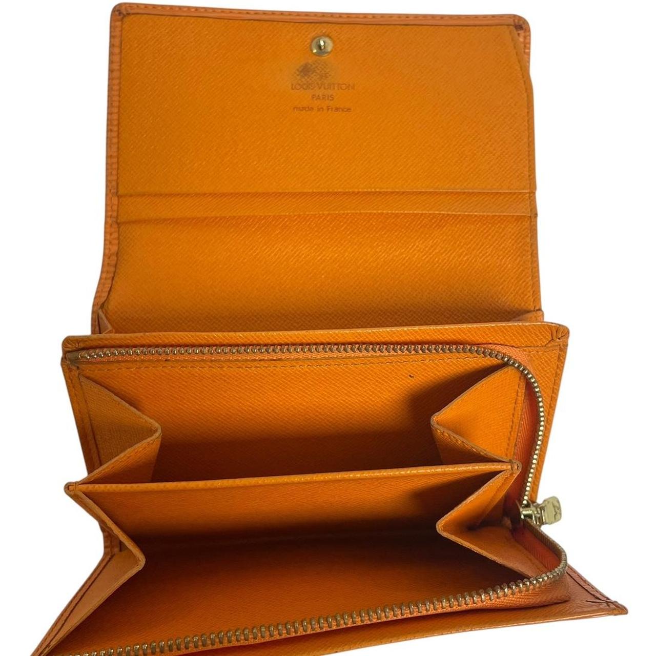 Louis Vuitton orange leather wallet with Epi texture and embossed logo detail.