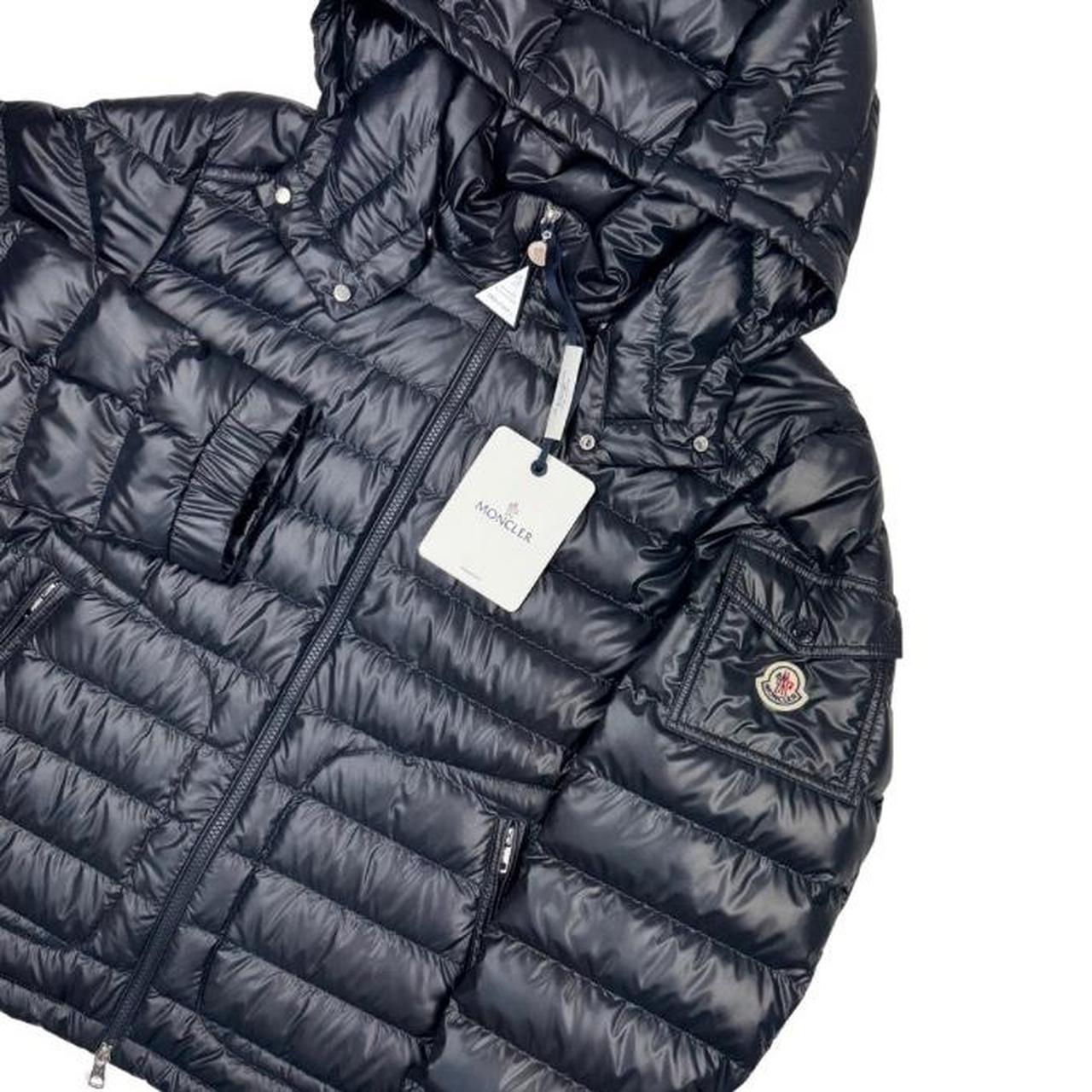 Moncler navy blue hooded puffer jacket with logo patch and nylon material.