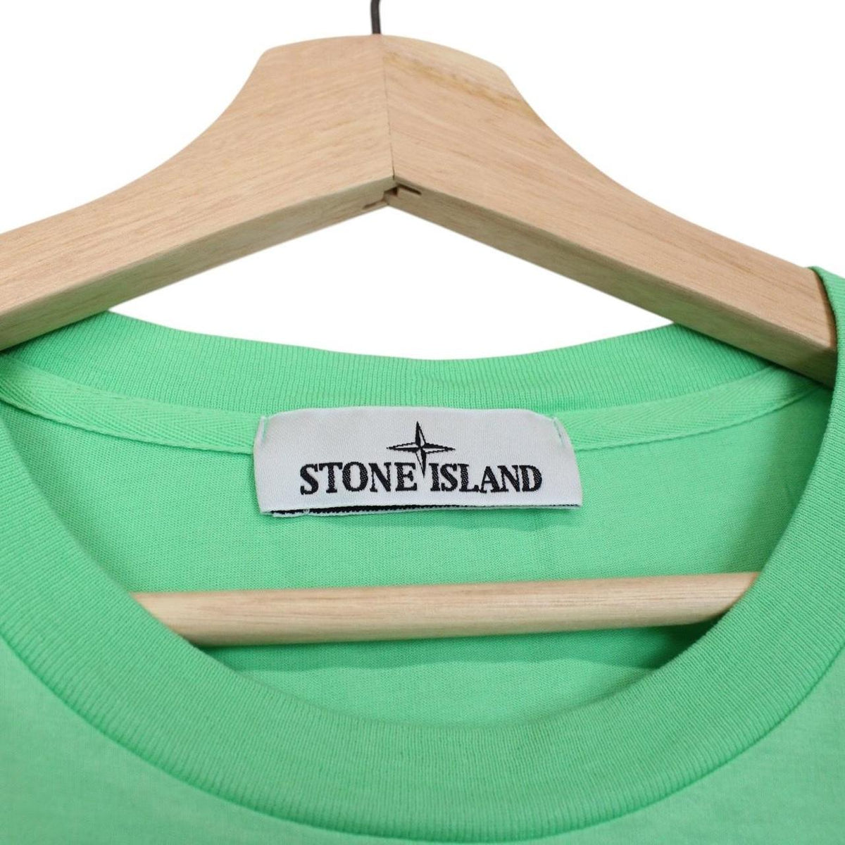 Stone Island green short sleeve cotton t-shirt with compass logo and tag detail.