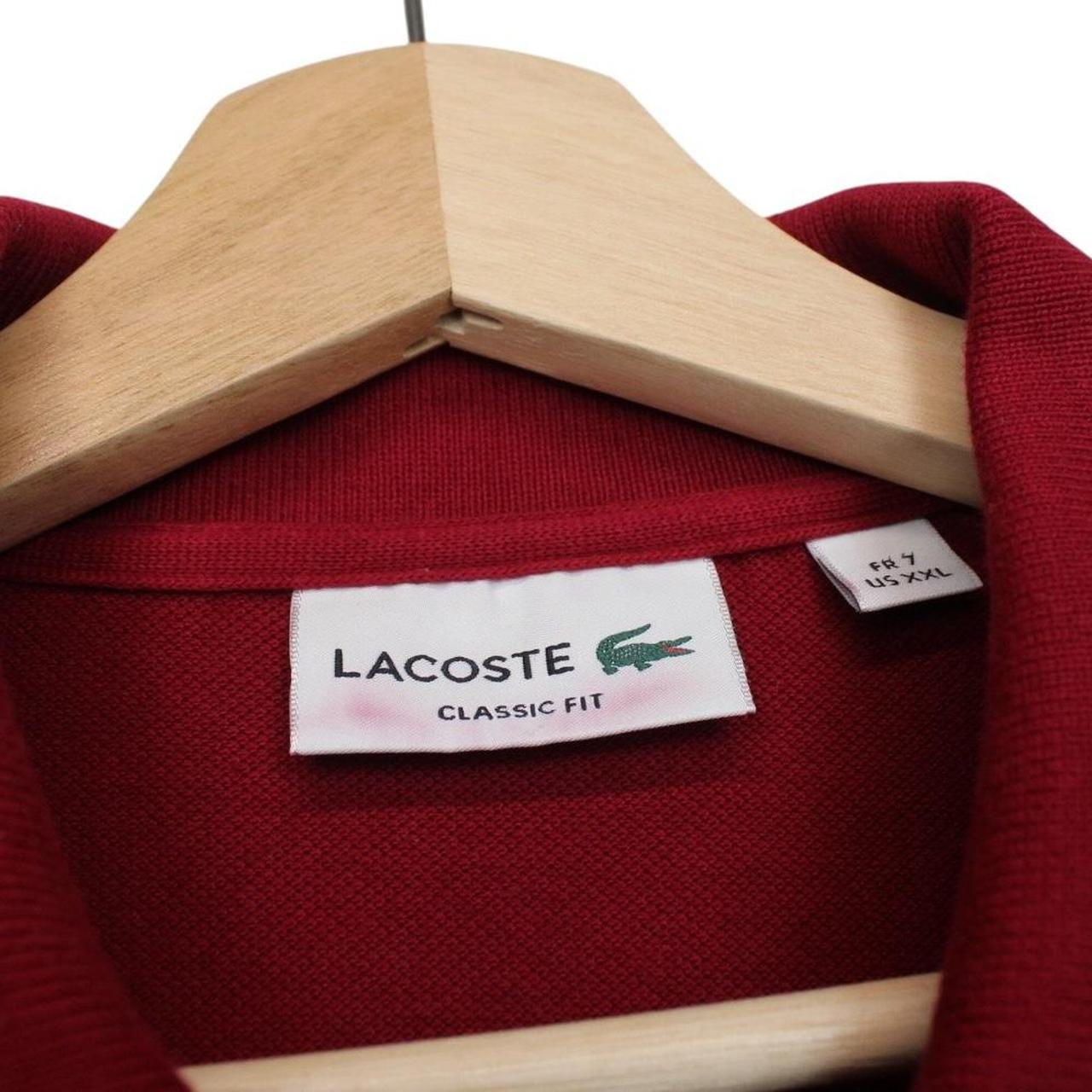 Lacoste burgundy polo shirt with embroidered crocodile logo and pocket detail.