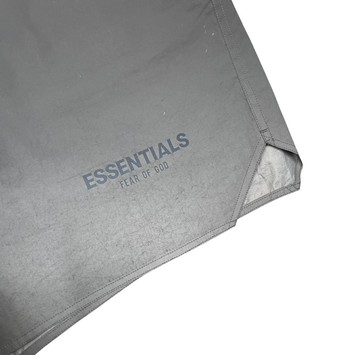 Essentials silver reflective nylon shorts with logo detail and sleek design.