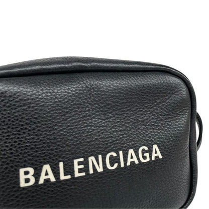 Balenciaga black leather messenger bag with embossed logo and minimalistic design.
