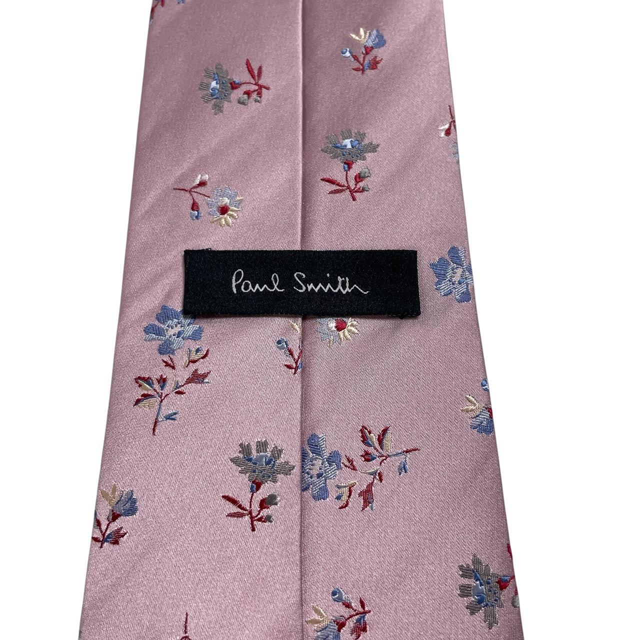 Paul Smith pink silk tie with floral embroidery and signature logo detail.