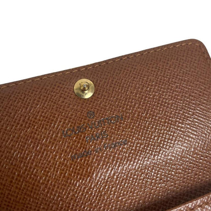 Louis Vuitton brown and tan monogram canvas key case with logo detail.