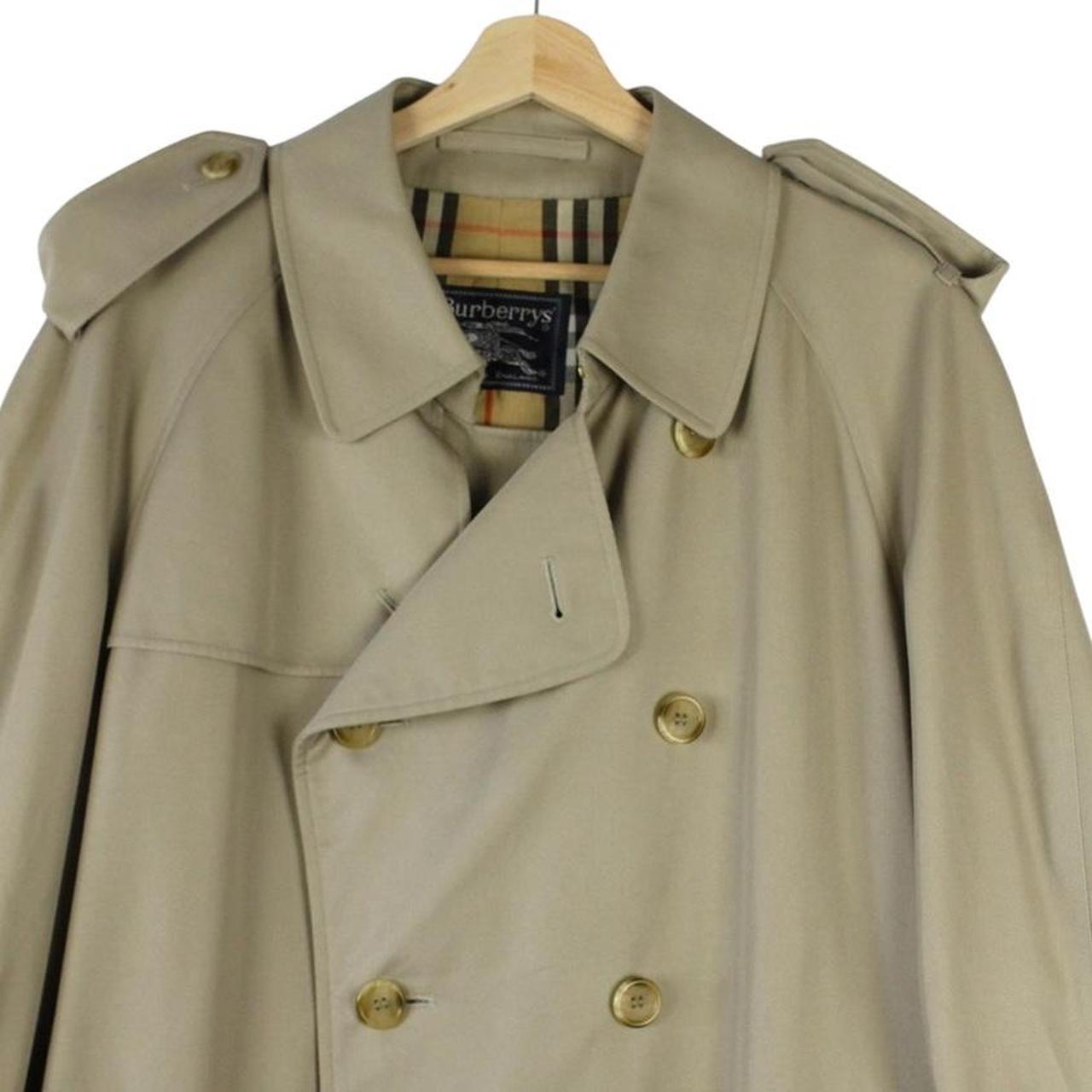 Burberry beige double-breasted belted trench coat with classic check lining and logo detail.