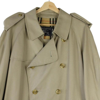 Burberry beige double-breasted belted trench coat with classic check lining and logo detail.