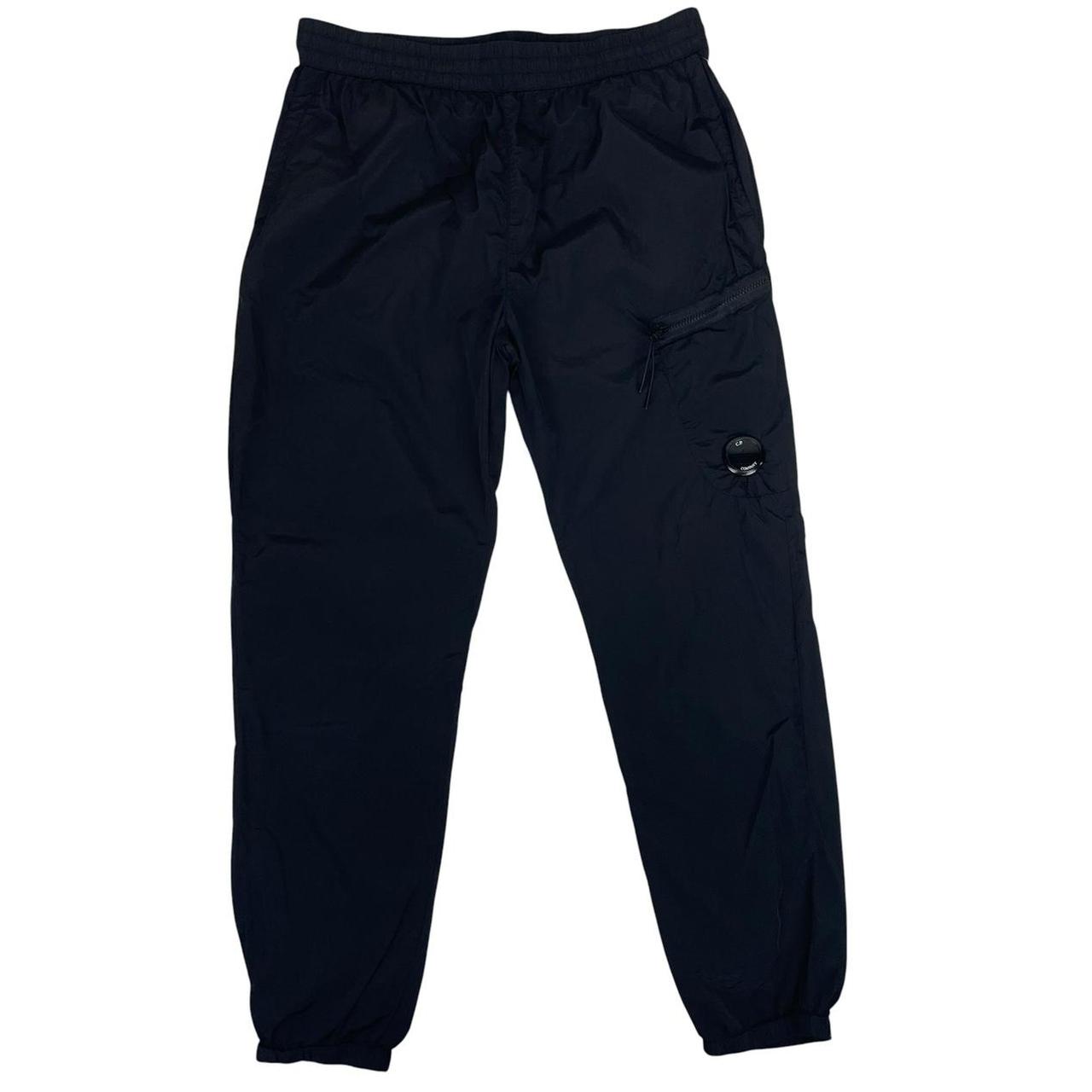 CP Company black cargo trousers with lens detail and nylon material.