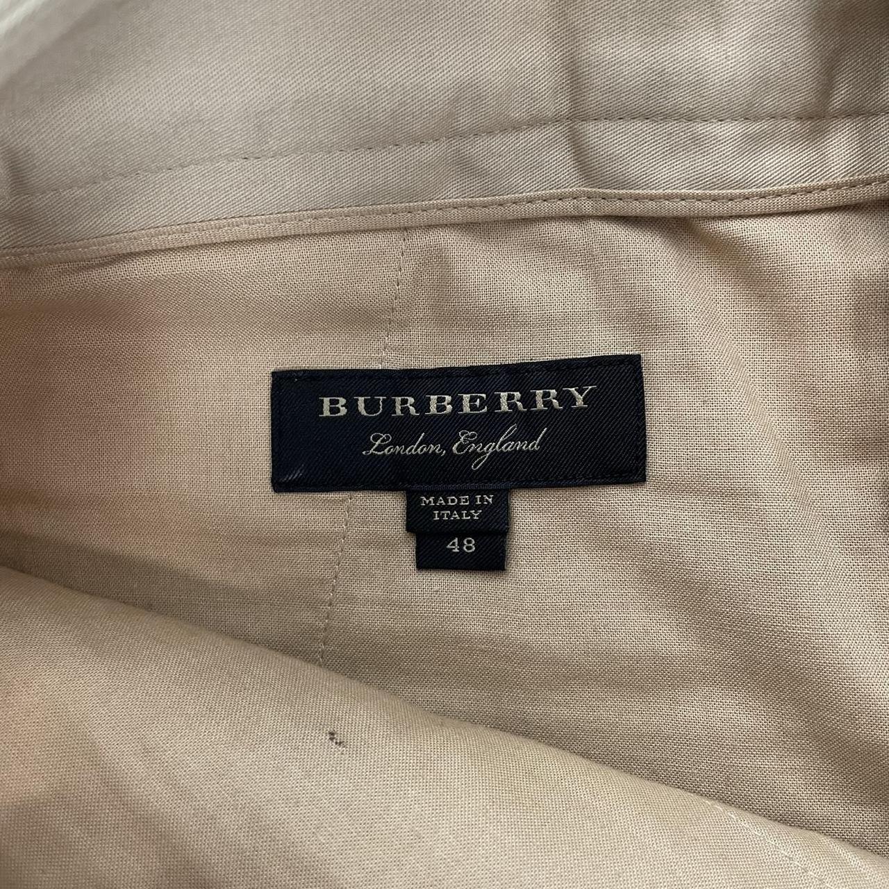 Burberry beige tapered fit trousers with sketch print design and cotton material.