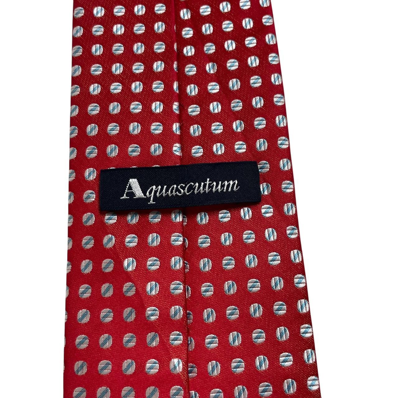 Aquascutum red silk tie with classic logo and smooth texture.