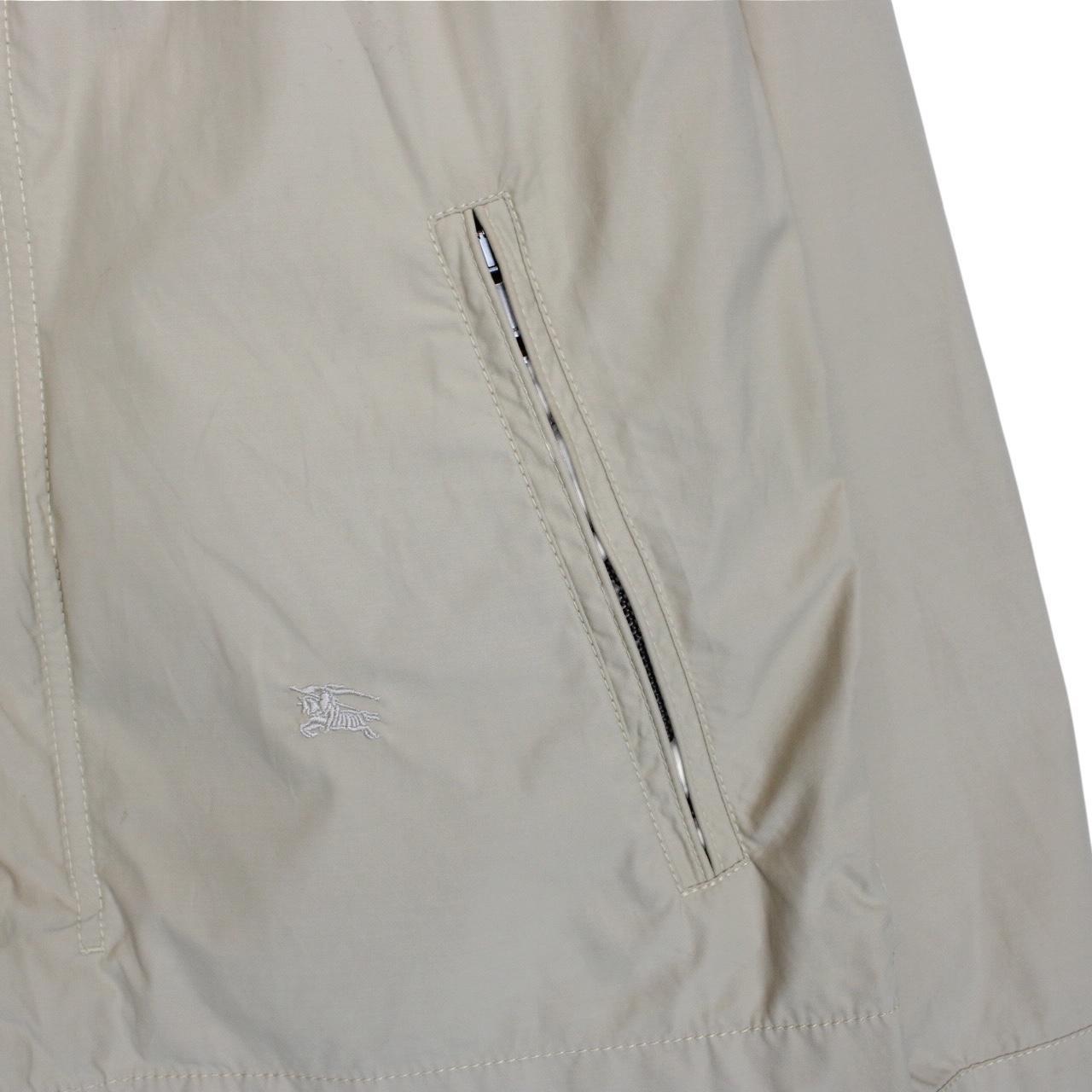 Burberry beige windbreaker jacket with full zip, logo detail, and nylon material.