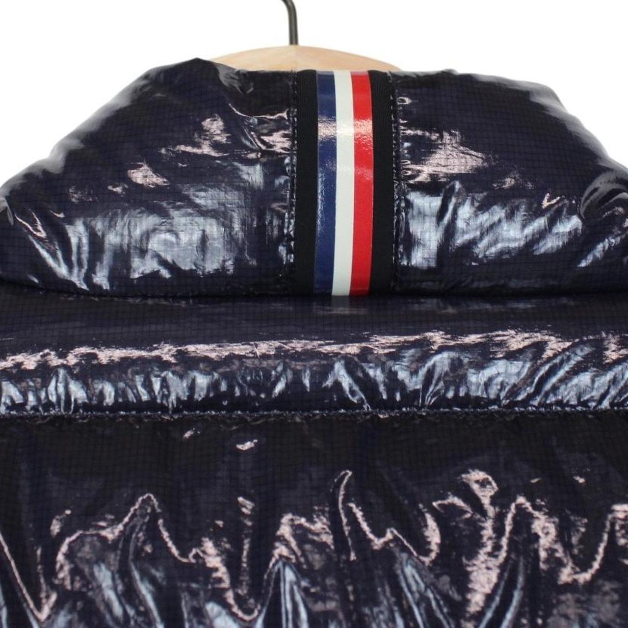 Moncler navy blue full zip down jacket with logo patch and quilted material.