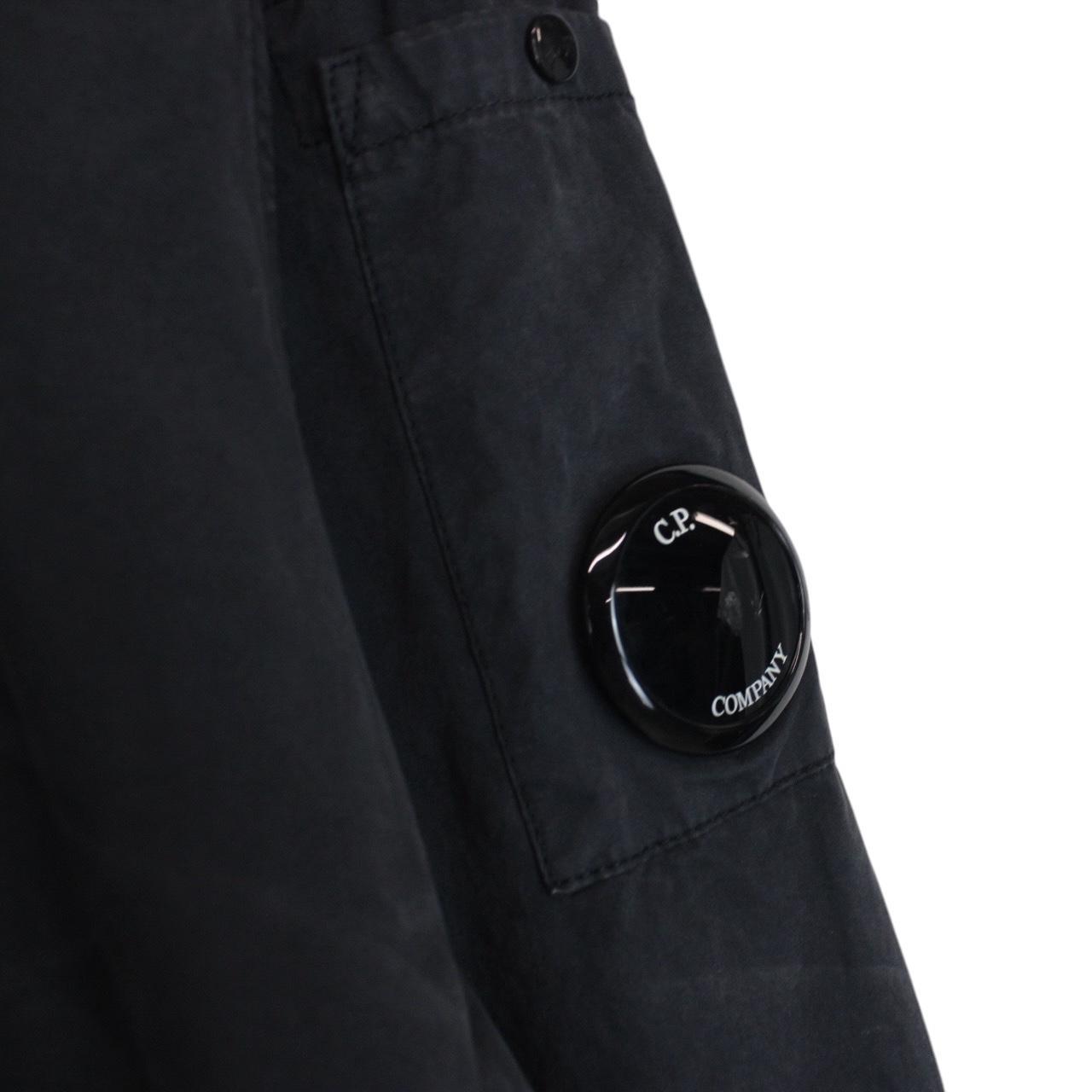 CP Company navy blue overshirt jacket with diamond pattern and lens detail.
