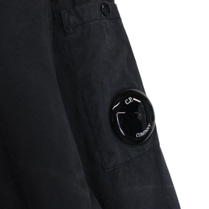 CP Company navy blue overshirt jacket with diamond pattern and lens detail.